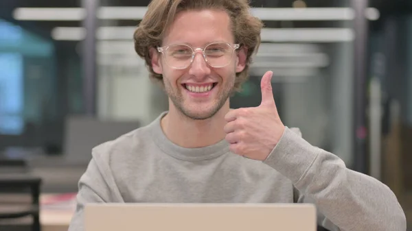 Retrato de polegares para cima por homem com laptop no trabalho — Fotografia de Stock