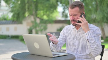 Kızgın Olgun Yetişkin Adam Açık Cafe 'de Telefonda Konuşuyor 