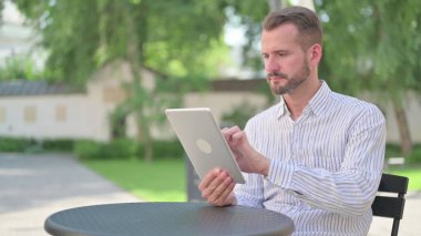 Açık Cafe 'de Tablet kullanan Olgun Yetişkin Adam 