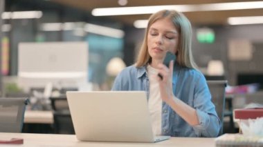 Laptop kullanırken Smartphone 'da Konuşan Genç Kadın 