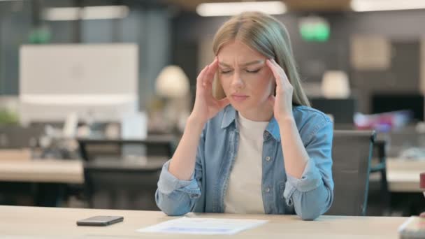 Молодая женщина с головной болью в современном офисе — стоковое видео