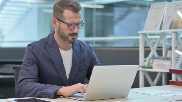 Középkorú üzletember köhögés használata közben Laptop az irodában — Stock videók