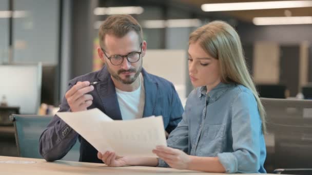 Empresario y Empresaria Discutiendo Documentos en la Oficina — Vídeos de Stock