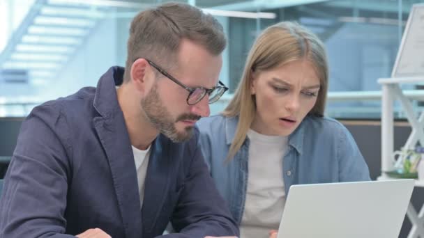 Colleague maschio e femmina che reagisce alla perdita sul computer portatile — Video Stock