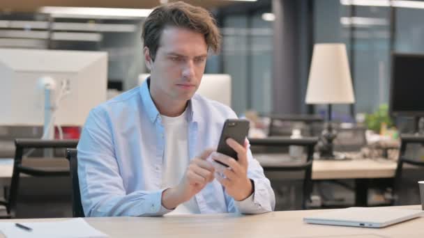 Hombre celebrando el éxito en el Smartphone en la oficina — Vídeos de Stock