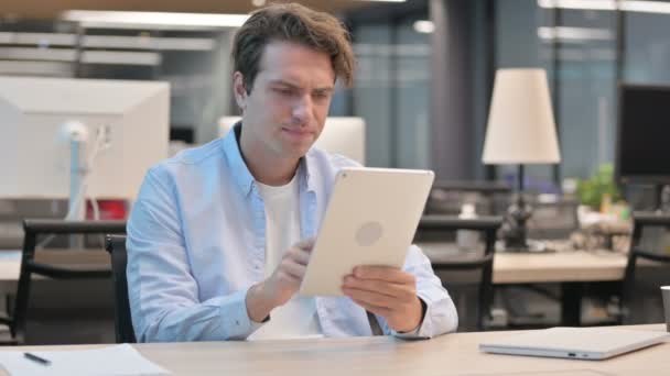 Hombre reaccionando a la pérdida en la tableta mientras está sentado en la oficina — Vídeo de stock