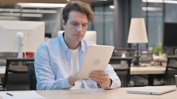 Homem usando Tablet enquanto sentado no escritório — Vídeo de Stock