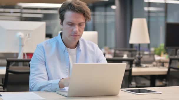 Uomo che ha mal di denti mentre lavora sul computer portatile in ufficio — Video Stock