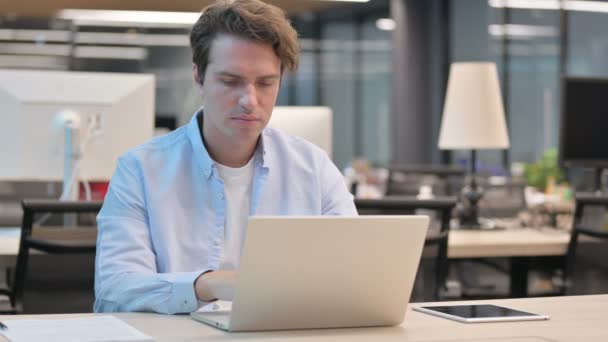 Uomo che ha dolore al collo durante l'utilizzo del computer portatile in ufficio — Video Stock