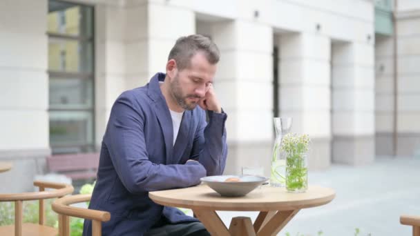Κουρασμένος άνθρωπος λαμβάνοντας υπνάκο, ενώ κάθεται σε υπαίθριο καφέ — Αρχείο Βίντεο