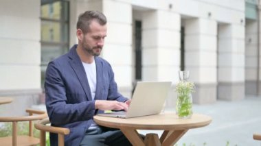 Laptop kullanırken Başparmakları Gösteren, Açık Cafe 'de oturan