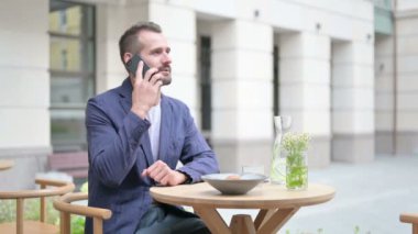 Smartphone 'da Konuşan Adam, Açık Cafe' de Oturan Yan Poz