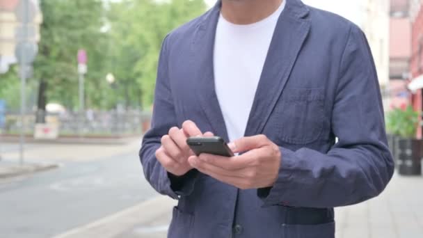 Primer plano Shot of Hands of Man Navegación de Internet en el teléfono inteligente mientras camina por la calle — Vídeos de Stock