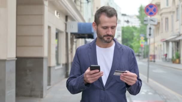Man handlar online på Smart Phone när du går längs gatan — Stockvideo