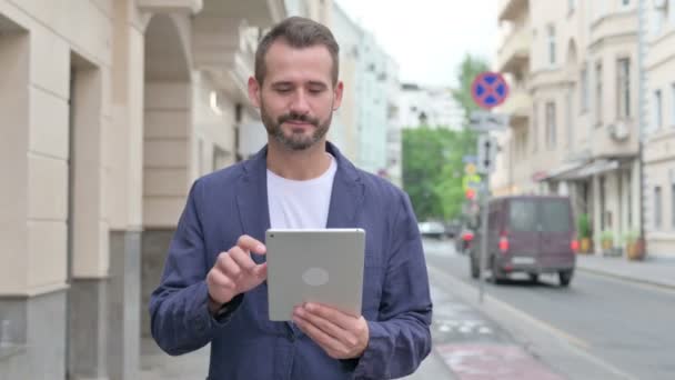 Щасливий зрілий дорослий чоловік переглядає Інтернет на планшеті під час ходьби по вулиці — стокове відео