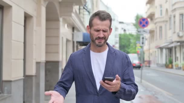 Man Having Loss on Phone while Walking Down the Street — Stock Video