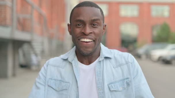 Utomhusporträtt av spännande afrikansk man firar framgång — Stockvideo