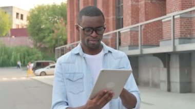 Sokakta yürürken Tablet kullanan Afrikalı Adam