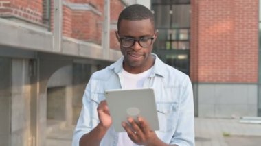 Sokakta yürürken Tablet üzerinde çalışan Afrikalı Adam