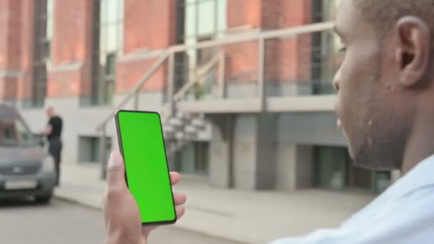 Hombre africano caminando con Smartphone de pantalla verde — Vídeos de Stock