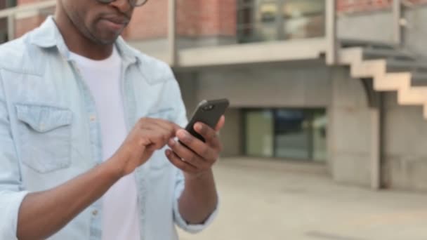 Fechar as mãos do homem africano usando Smartphone enquanto caminha na rua — Vídeo de Stock