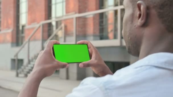 Homme africain Regarder Smartphone avec écran vert — Video