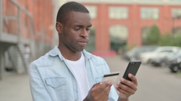 Африканский человек делает покупки онлайн на улице — стоковое видео