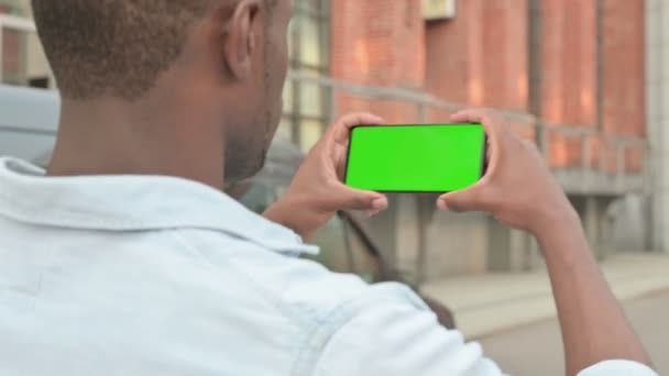 Outdoor Afrikaanse Man Holding Smartphone met groen scherm — Stockvideo