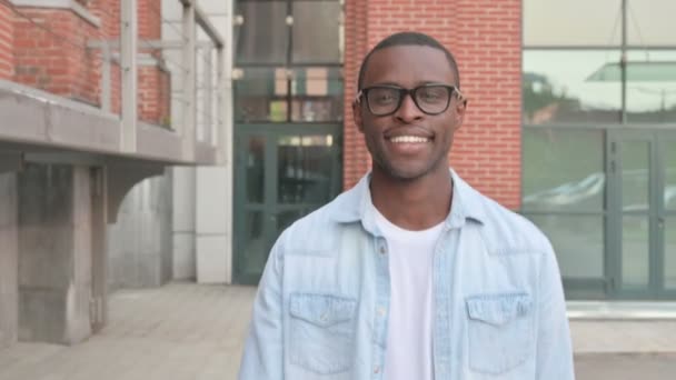Primer plano del hombre africano sonriente caminando en la calle, frente a la postura — Vídeo de stock