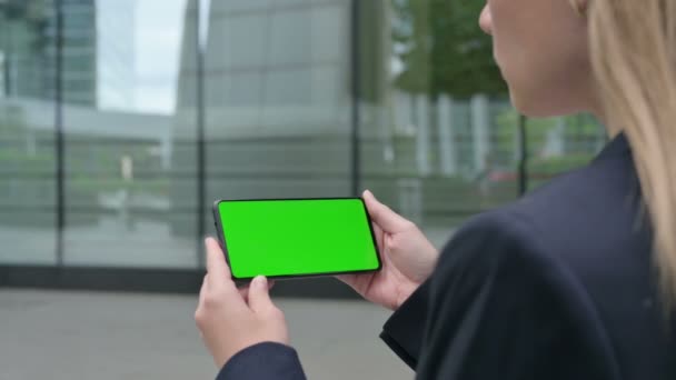 带绿色彩色屏幕的企业妇女观看智能手机的后视镜 — 图库视频影像