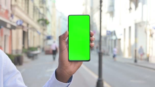 Visão traseira do homem africano Olhando para Smartphone com tela Chroma verde — Vídeo de Stock