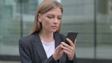 Genç iş kadını akıllı telefon kullanırken kayboluyor. 