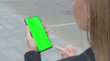 İş kadınının Yeşil Krom Ekran ile Akıllı Telefona Bakışı 