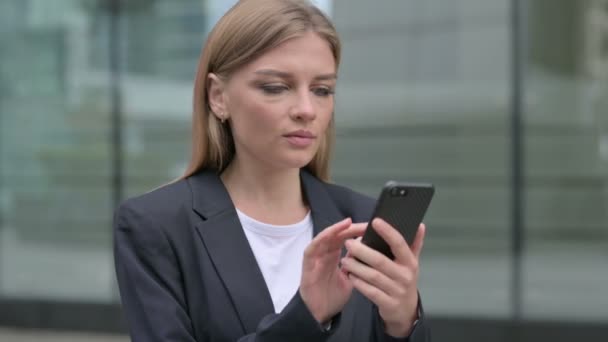 Молодая предпринимательница с помощью смартфона, на открытом воздухе — стоковое видео