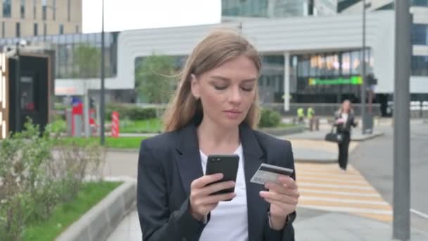 Деловая женщина делает онлайн оплату на смартфоне во время прогулки — стоковое видео