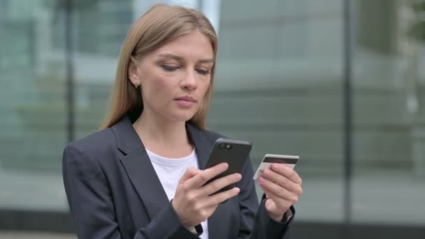 Молодая предпринимательница разговаривает по телефону, на открытом воздухе — стоковое видео