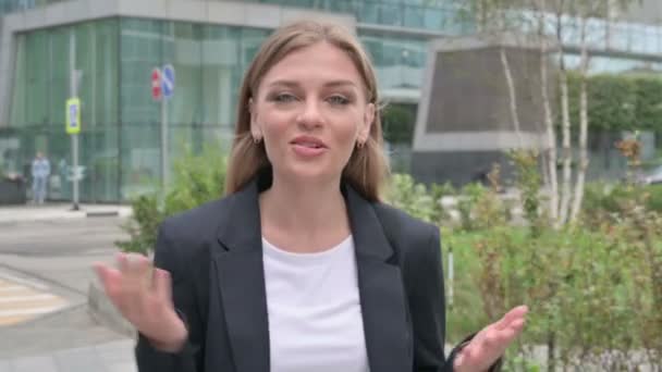 Молодая предпринимательница разговаривает на онлайн-видео-звонок во время прогулки по улице — стоковое видео