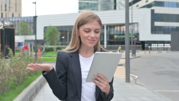 Joven empresaria hablando en videollamada en tableta mientras camina por la calle — Vídeos de Stock