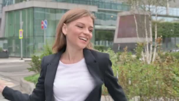 Молода бізнес-леді танцює в радості під час ходьби на вулиці — стокове відео