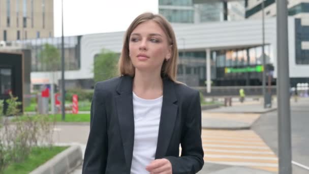 Ernstige jonge zakenvrouw wandelen op straat terwijl kijken rond — Stockvideo