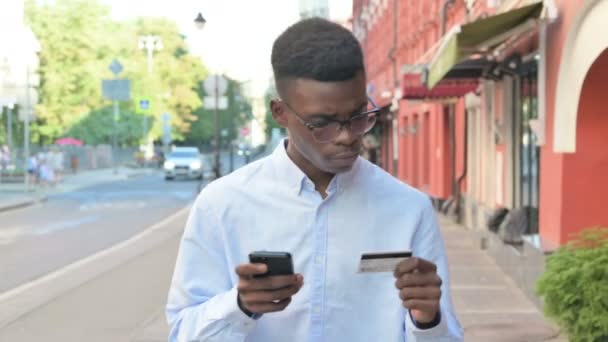 Afrikaanse Man maakt succesvolle Online Betaling op Smartphone in de straat — Stockvideo