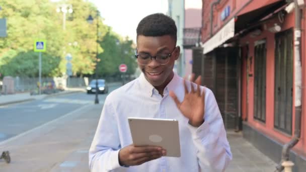 Afrikaanse man het maken van video call op Tablet tijdens het lopen op straat — Stockvideo