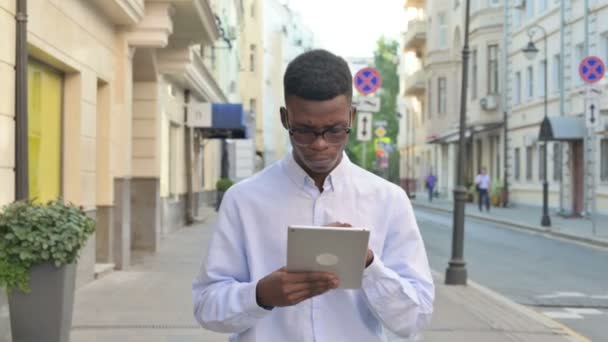Αφρικανός που εργάζεται σε tablet, ενώ το περπάτημα στο δρόμο — Αρχείο Βίντεο