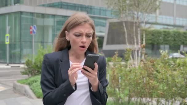 Young Businesswoman Reacting to Loss on Smartphone while Walking on the Street — Stok Video