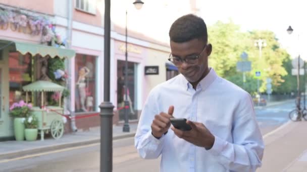 Wandelen Afrikaanse Man Browsing Internet op Smartphone — Stockvideo