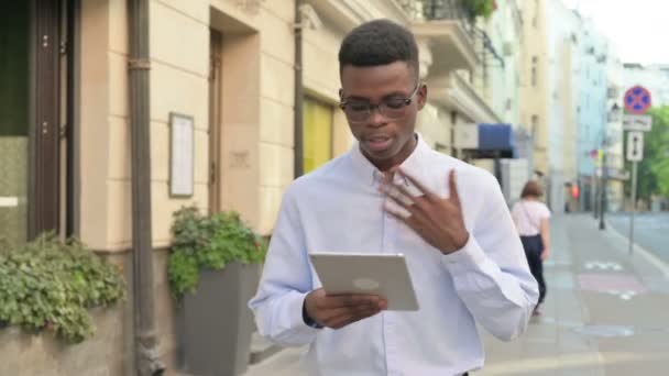 Homem Africano fazendo Vídeo Chamada em Tablet enquanto Caminhando na Rua — Vídeo de Stock