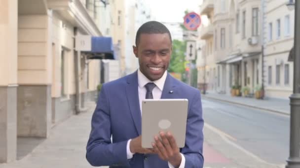 Empresario africano haciendo video chat en la tableta mientras camina por la calle — Vídeos de Stock