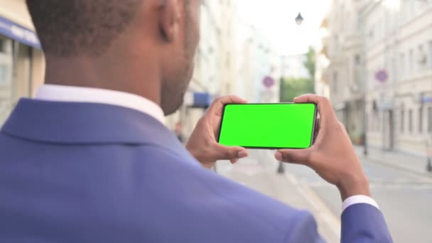 Empresário Africano Olhando para Smartphone com tela Chroma verde — Vídeo de Stock