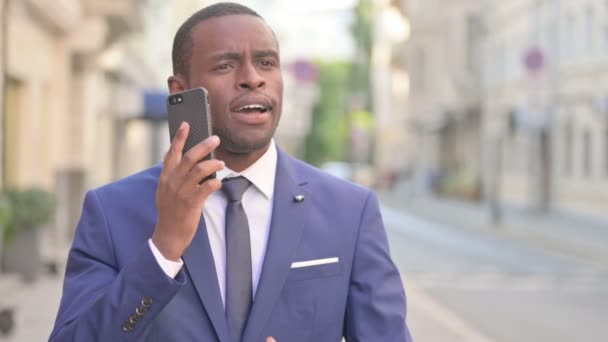 Hombre de negocios africano al aire libre hablando en Smartphone — Vídeos de Stock