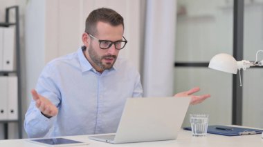 Orta yaşlı adam dizüstü bilgisayarda çalışırken şok olmuş hissediyor 